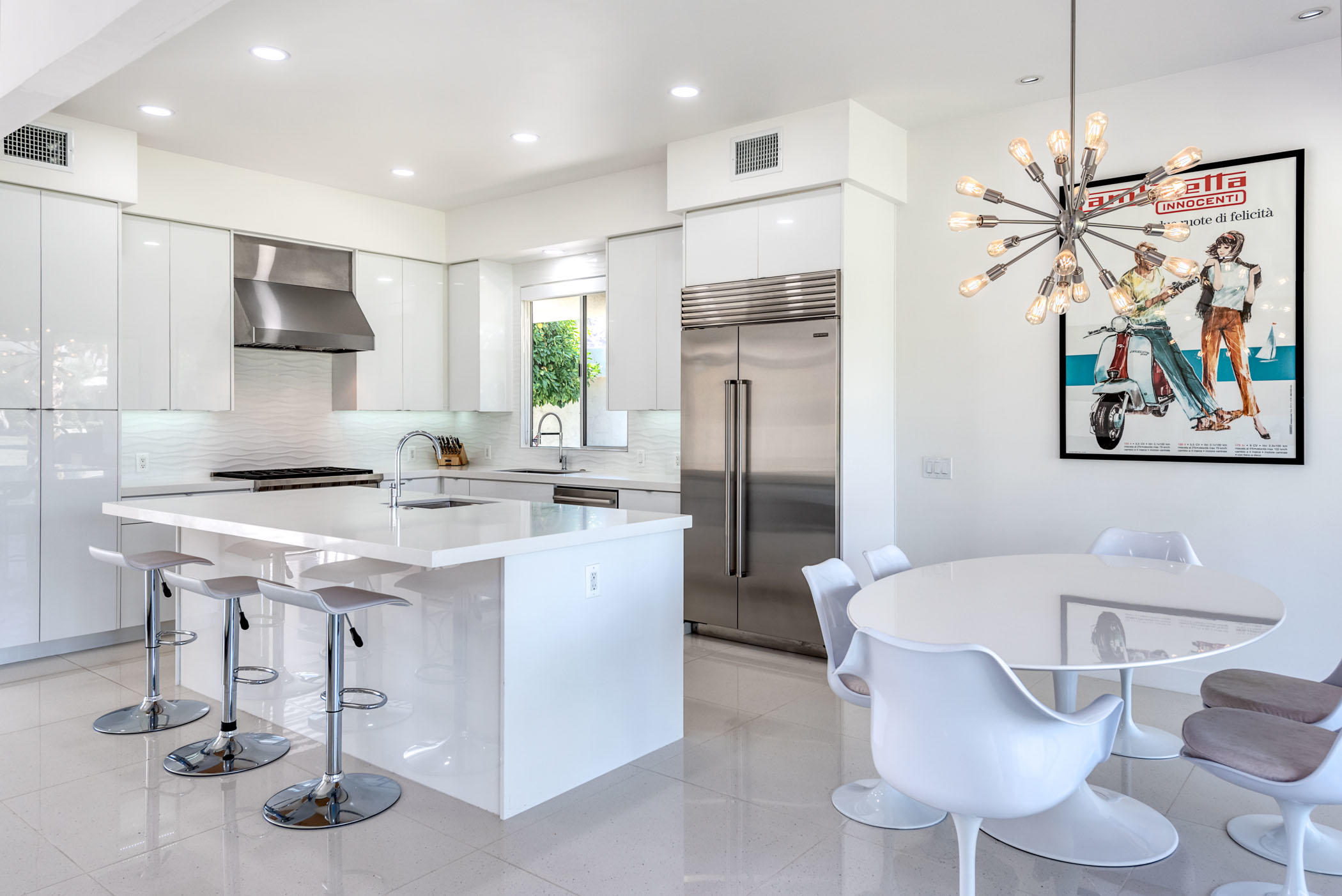 45765 Hopi Road Indian Wells, CA 92210 - Photo 7 of 39 a kitchen with stainless steel appliances kitchen island granite countertop a refrigerator a sink a stove and a dining table with wooden floor