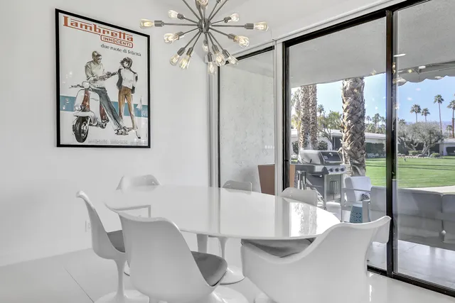 a large white kitchen with a white countertops a stove and a chandelier