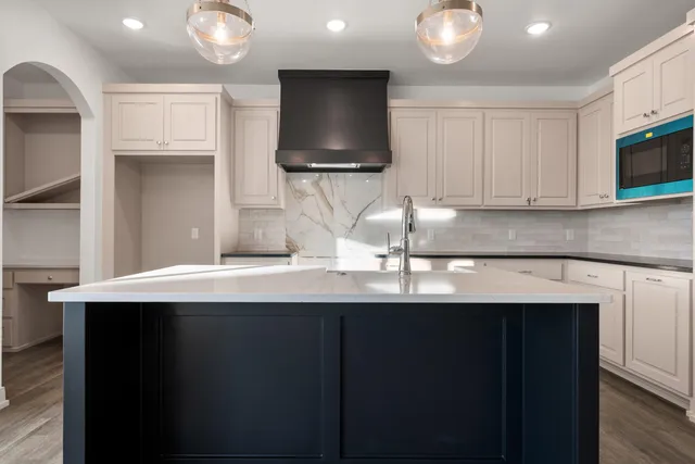 a kitchen with stainless steel appliances a sink dishwasher a stove and a microwave oven on granite countertops