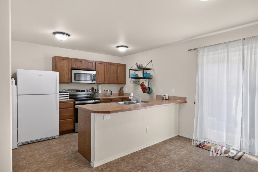 1337 Bristol Road Moscow, ID 83843 - Photo 9 of 28 Kitchen featuring wood-finish cabinetry, stainless steel microwave, and a breakfast bar