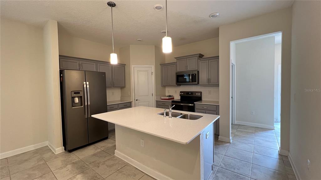 15216 Chapter Way Winter Garden, FL 34787 - Photo 21 of 53 a kitchen that has a refrigerator a stove a sink and a wooden floor