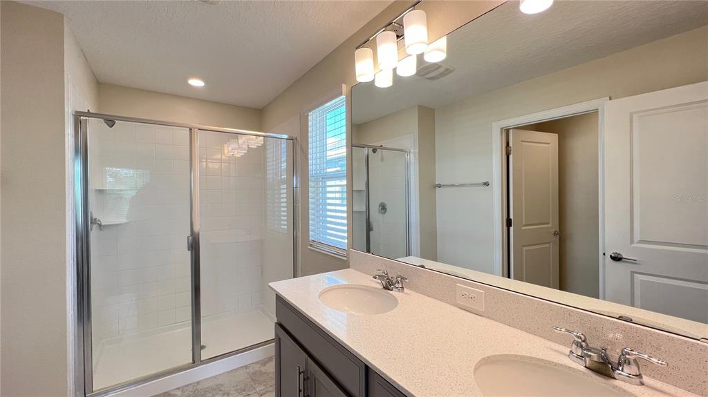 15216 Chapter Way Winter Garden, FL 34787 - Photo 43 of 53 a bathroom with a sink vanity granite shower and a mirror