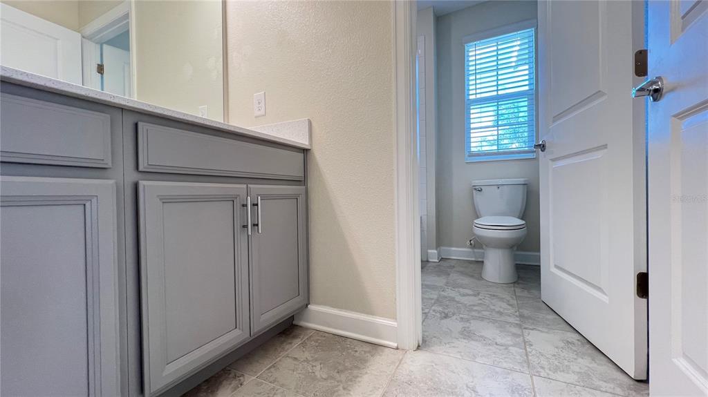 15216 Chapter Way Winter Garden, FL 34787 - Photo 52 of 53 a bathroom with a toilet a sink and a window