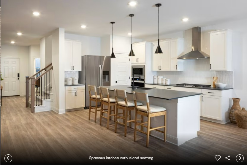 16809 Catemaco Walk Manor, TX 78653 - Photo 10 of 11 a kitchen with stainless steel appliances kitchen island granite countertop a table chairs refrigerator and microwave