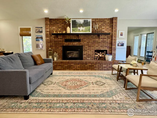 a kitchen with stainless steel appliances granite countertop a sink a stove a dining table and chairs with wooden floor