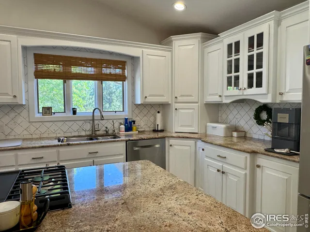 a kitchen with a stove a kitchen island a dining table and chairs with the wooden floor