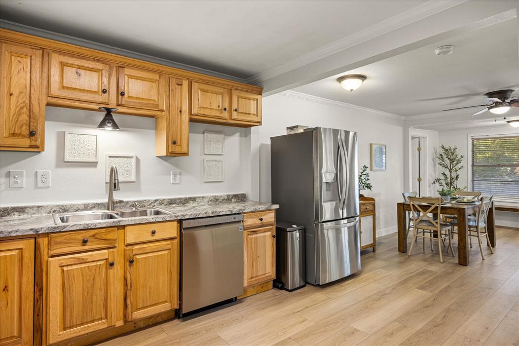 310 West 6th Street Tolar, TX 76476 - Photo 5 of 27 a kitchen with granite countertop stainless steel appliances a refrigerator cabinets and wooden floor