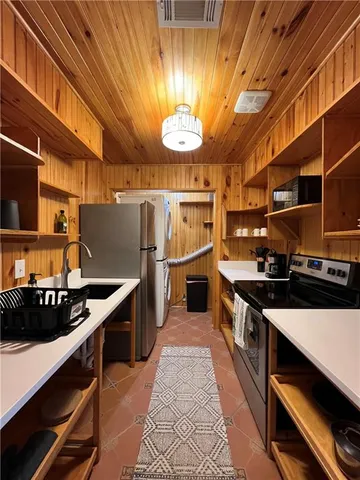 a kitchen with stainless steel appliances a stove a sink and a refrigerator