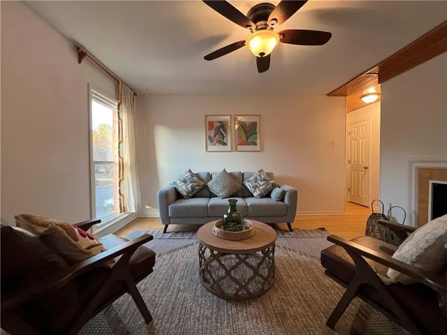 a living room with furniture a ceiling fan and a window