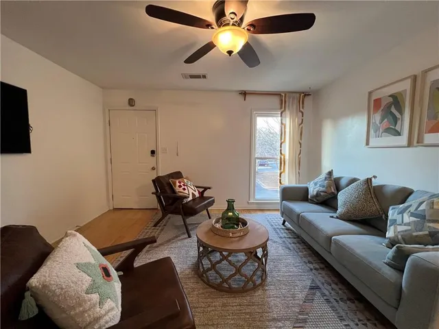 a living room with furniture and a ceiling fan