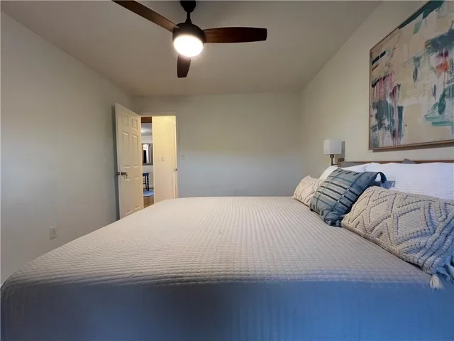 a bedroom with a large bed and a chandelier