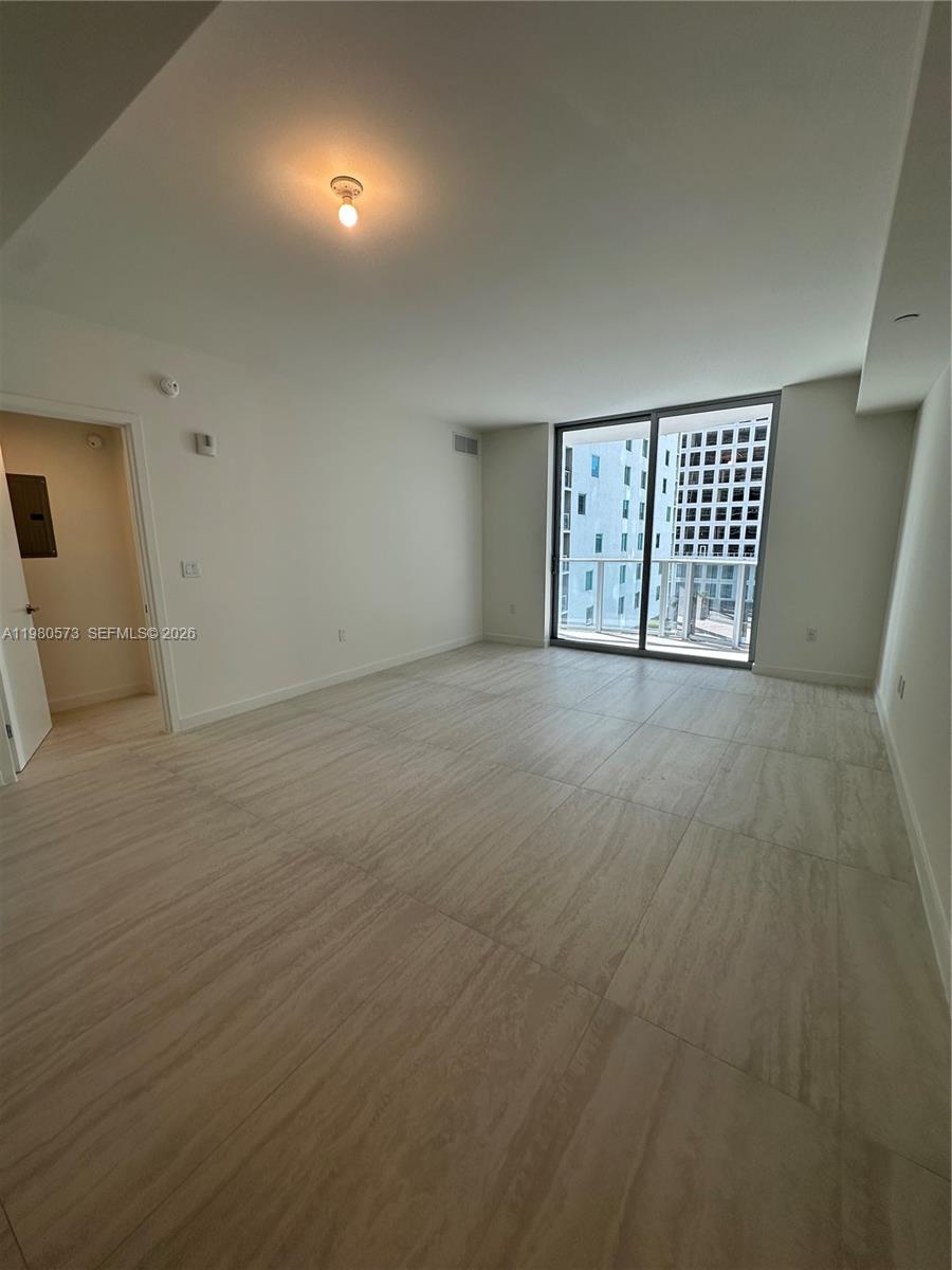 77 Southeast 5th Street, Unit 1514 Miami, FL 33131 - Photo 4 of 16 an empty room with a window and mirror