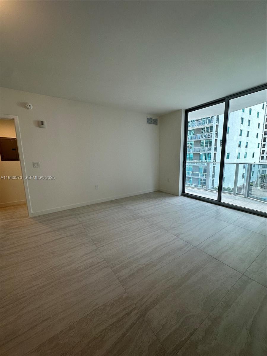 77 Southeast 5th Street, Unit 1514 Miami, FL 33131 - Photo 5 of 16 wooden floor in an empty room with a window
