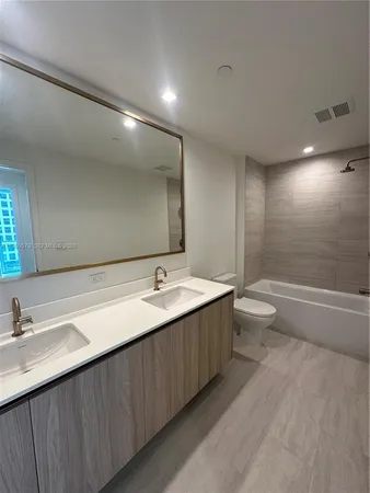 a bathroom with a double vanity sink and a large mirror