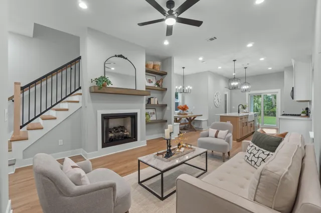 a living room with furniture a fireplace and a ceiling fan