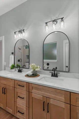 a bathroom with double vanity sinks and a mirror