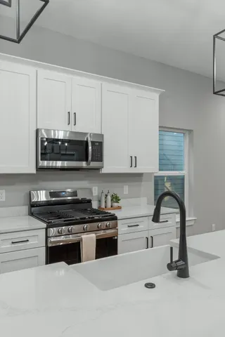 a kitchen with granite countertop a stove and a sink