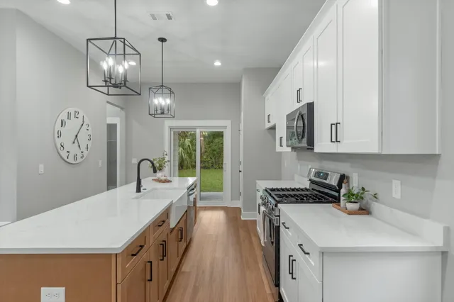 a kitchen that has a lot of cabinets and wooden floor