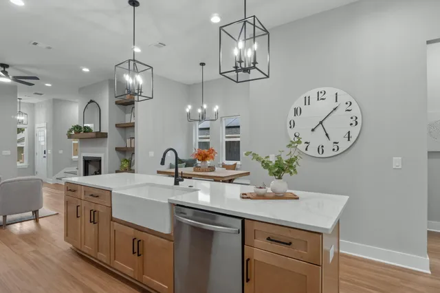 a kitchen with a sink a clock and cabinets