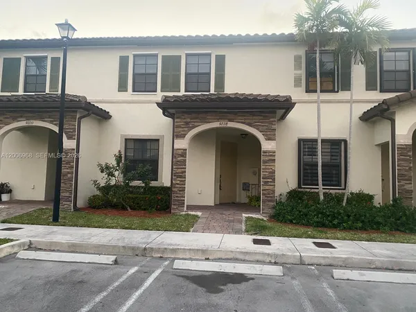a front view of a house with a garden and plants