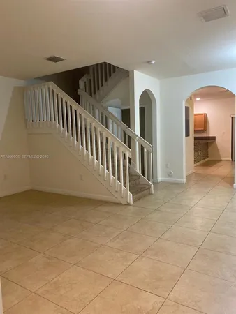 a view of staircase with white walls and chandelier