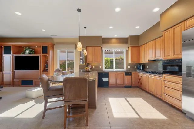 a dining room with furniture a chandelier and a flat screen tv