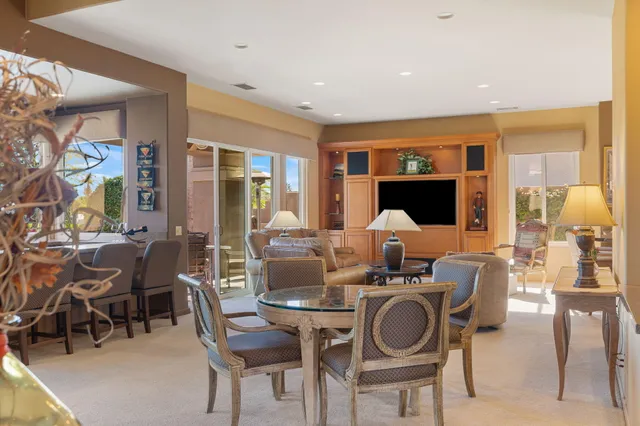 a bedroom with a bed a chair and potted plant on the dresser