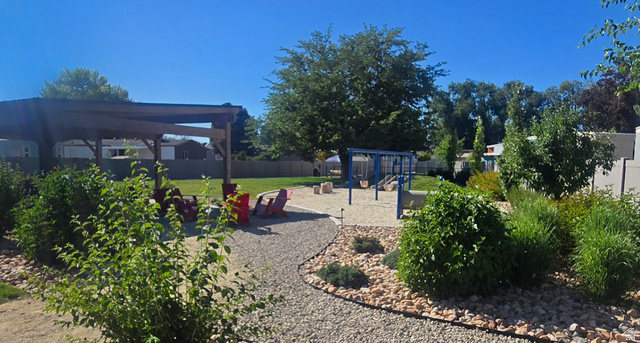 1500 Angel Street North, Unit 53 Layton, UT 84041 - Photo 16 of 20 Expansive backyard featuring a gravel path, a wooden pergola, a lawn area, a swing set, and mature trees and shrubs
