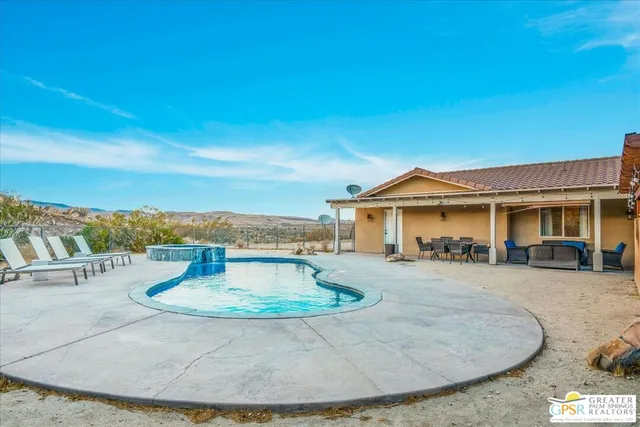 a view of a house with swimming pool and sitting area