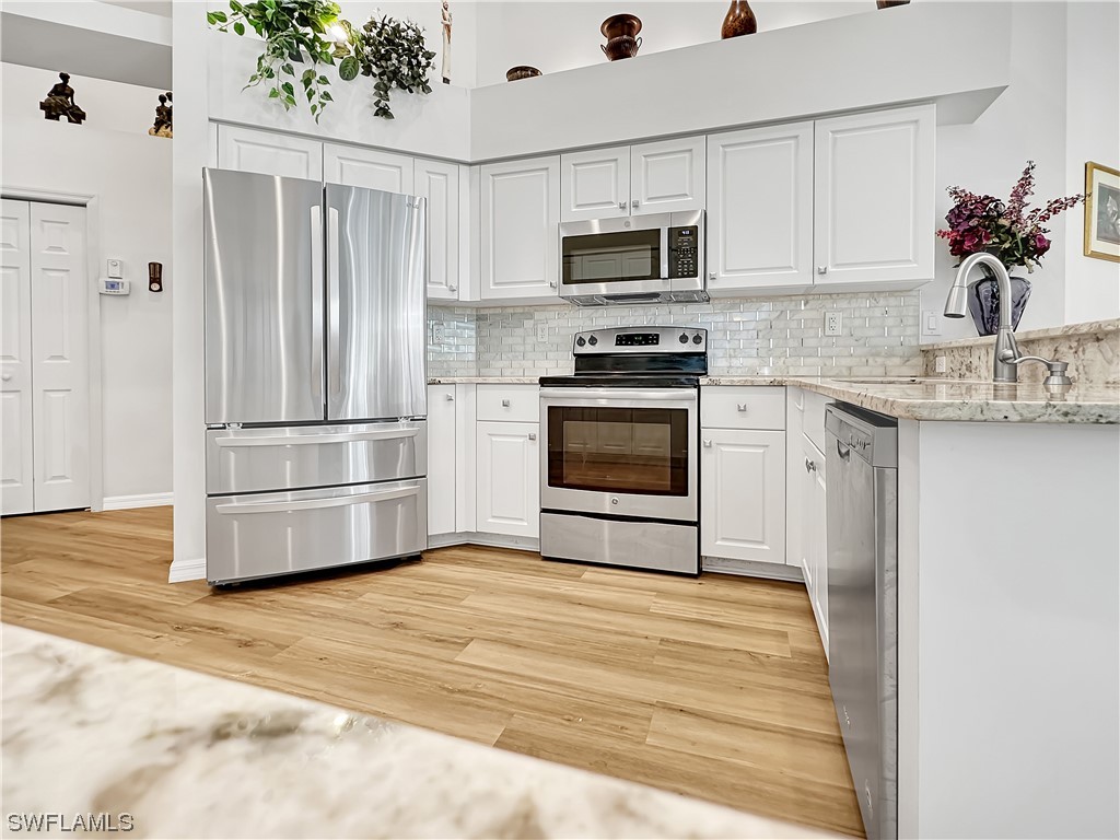 20631 Rivers Ford Estero, FL 33928 - Photo 2 of 18 a kitchen with granite countertop a refrigerator stove and microwave