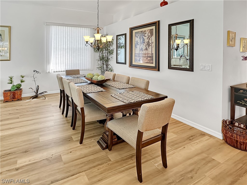 20631 Rivers Ford Estero, FL 33928 - Photo 7 of 18 a dining room with wooden floor a chandelier a wooden table and chairs