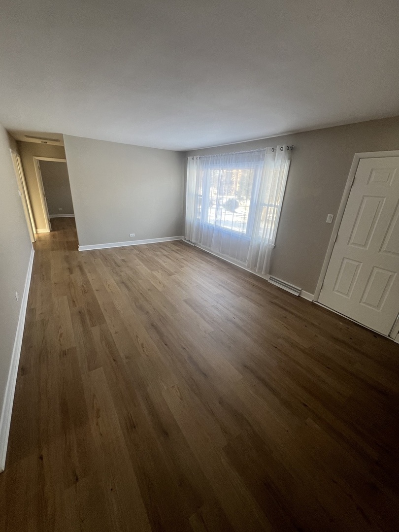 213 67th Street Darien, IL 60561 - Photo 2 of 13 wooden floor in an empty room with a window