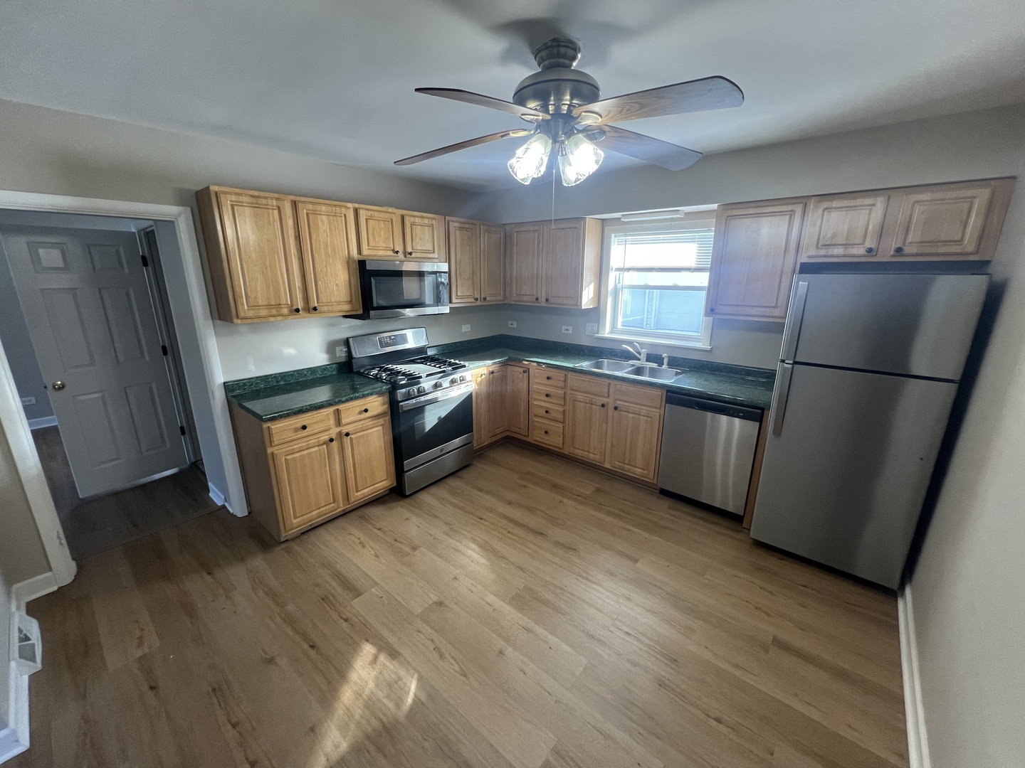 213 67th Street Darien, IL 60561 - Photo 3 of 13 a kitchen with stainless steel appliances granite countertop a refrigerator a sink dishwasher a stove and white countertops with wooden floor