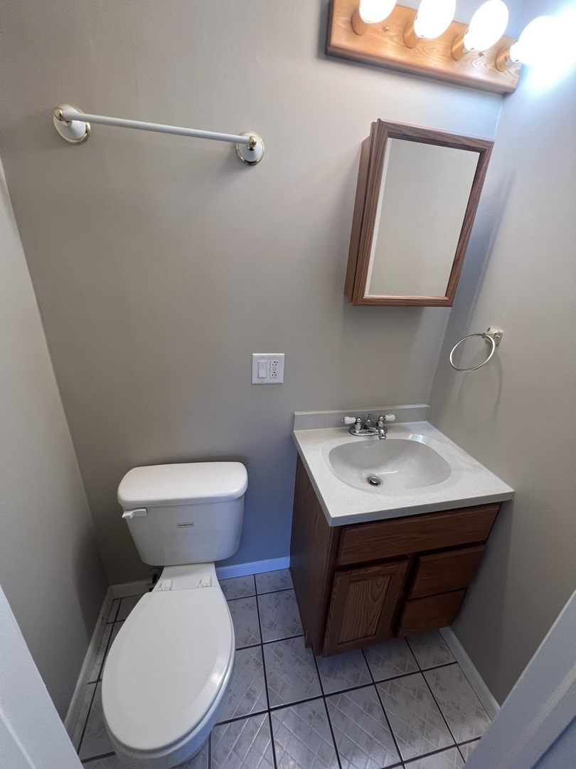 213 67th Street Darien, IL 60561 - Photo 5 of 13 a bathroom with a toilet a sink and mirror