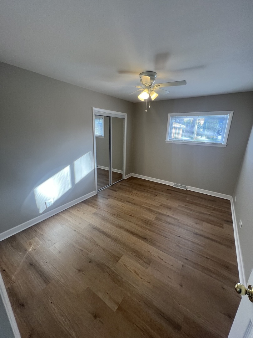 213 67th Street Darien, IL 60561 - Photo 7 of 13 an empty room with wooden floor chandelier and windows