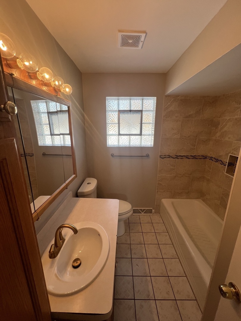 213 67th Street Darien, IL 60561 - Photo 9 of 13 a bathroom with a sink and a mirror