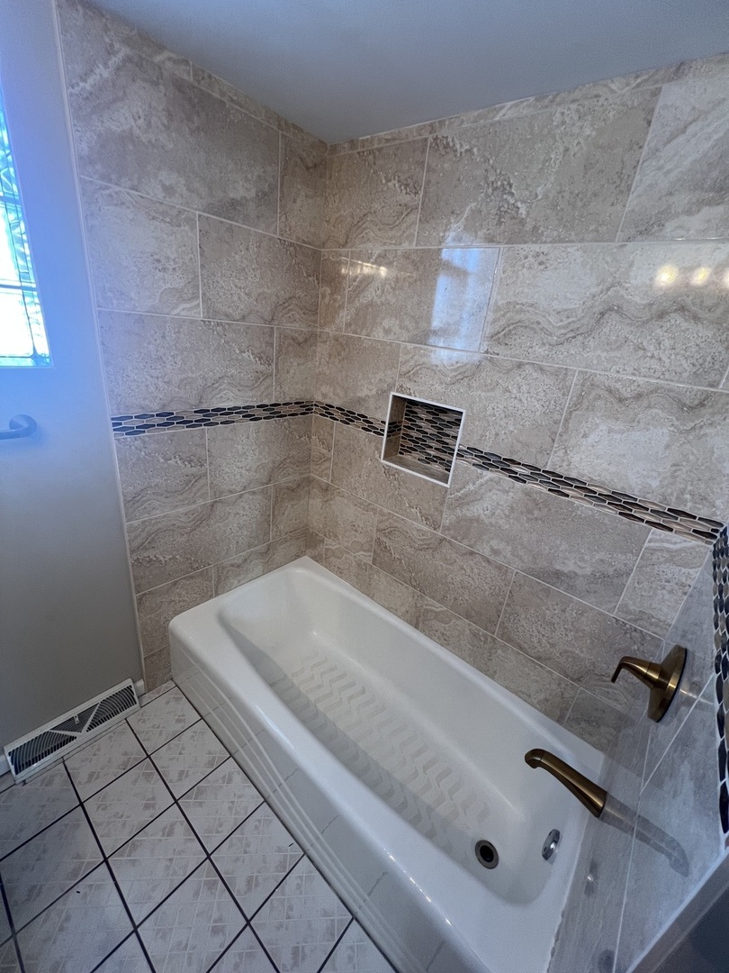 213 67th Street Darien, IL 60561 - Photo 10 of 13 a bathroom with a bathtub