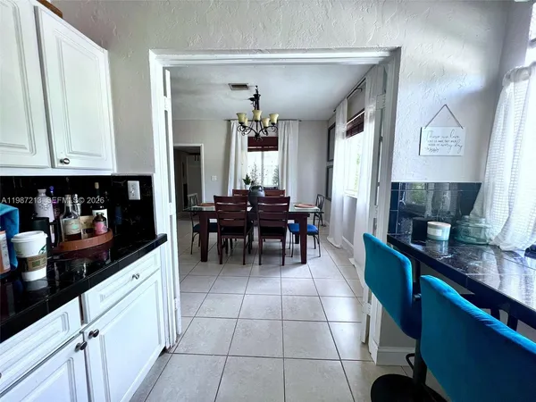 a kitchen with granite countertop cabinets table and chairs