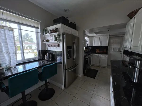 a kitchen with a refrigerator a sink and cabinets