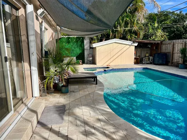 a view of backyard with a table and chairs and potted plants