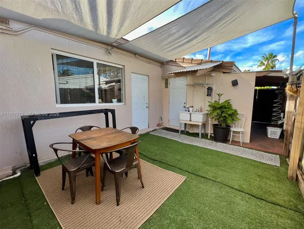 a view of a house with backyard and sitting area