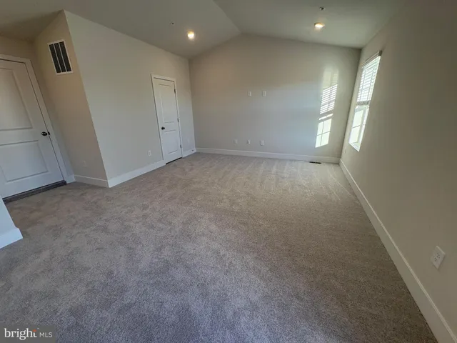 an empty room with windows and closet