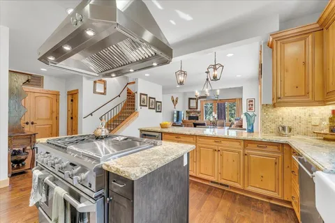 a very nice looking kitchen with a center island wooden floor and stainless steel appliances