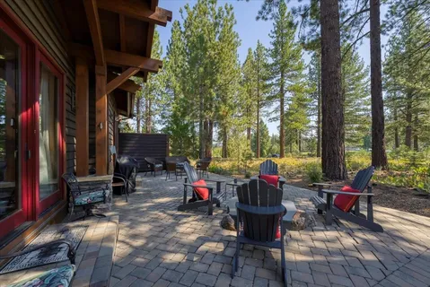 a view of a building with sitting area and large trees