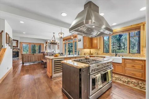 a kitchen with stainless steel appliances granite countertop a stove and a wooden floors