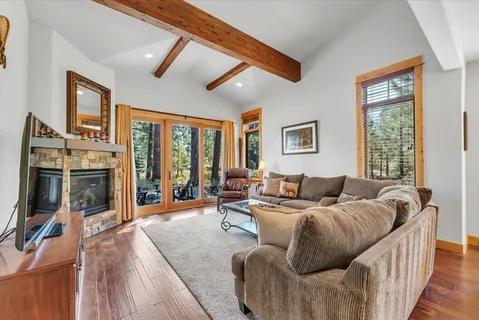 a living room with furniture large window and flat screen tv