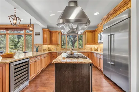 a kitchen with stainless steel appliances granite countertop a sink a stove and a refrigerator