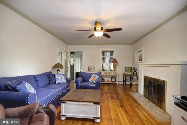 a living room with furniture a fireplace and wooden floor