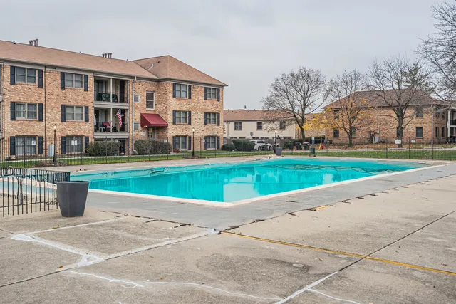 a view of a big building with a big yard and large trees