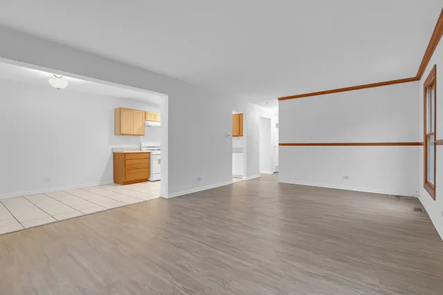 a view of an empty room with wooden floor and a cabinet